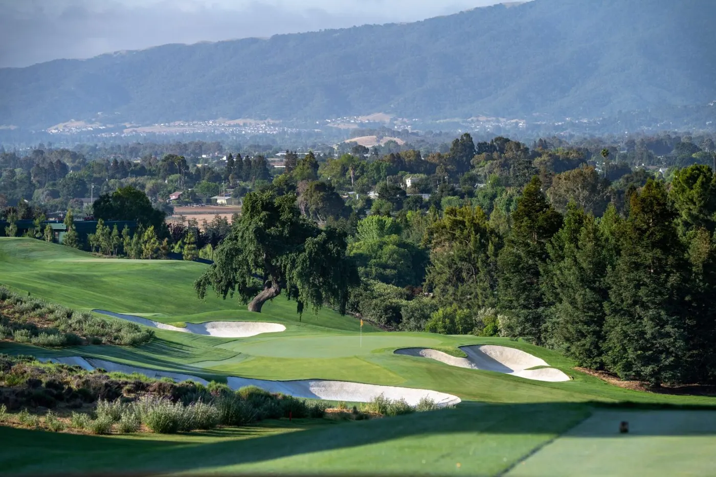 Green and bunkers at The Institute with the valley and mountains behind